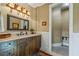 Bathroom with wainscotting, a wood vanity, and decorative sconce lighting at 4239 Lower Jersey Rd, Covington, GA 30014
