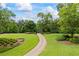 Long, winding driveway leading to a secluded property with lush greenery and mature trees at 4239 Lower Jersey Rd, Covington, GA 30014