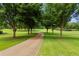 Gravel driveway lined with trees, leading to a manicured lawn at 4239 Lower Jersey Rd, Covington, GA 30014