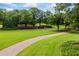 Curving driveway leading through a manicured lawn with mature trees and landscaping at 4239 Lower Jersey Rd, Covington, GA 30014
