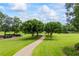 Gravel driveway winding through a lush green landscape with mature trees and manicured lawns at 4239 Lower Jersey Rd, Covington, GA 30014