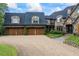 Elegant stone home showcasing a three-car garage, lush landscaping, and driveway at 4239 Lower Jersey Rd, Covington, GA 30014