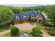 Beautiful stone home featuring a three-car garage, pond, and lush landscaping at 4239 Lower Jersey Rd, Covington, GA 30014
