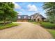 Exterior view of stone home featuring a gravel driveway, and mature landscaping at 4239 Lower Jersey Rd, Covington, GA 30014