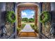 Ornate wrought iron double doors open to a manicured front yard with stone pathway at 4239 Lower Jersey Rd, Covington, GA 30014