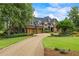 Stunning stone home featuring a curved driveway, three-car garage, and professionally landscaped yard at 4239 Lower Jersey Rd, Covington, GA 30014