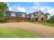 Charming stone home featuring a curved driveway and attached three-car garage at 4239 Lower Jersey Rd, Covington, GA 30014