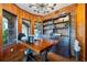 Bright office with wood walls, brick accent, and custom built-in shelving with a large desk at 4239 Lower Jersey Rd, Covington, GA 30014