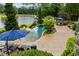 Relaxing pool area with lounge chairs, lush landscaping, and lake views at 4239 Lower Jersey Rd, Covington, GA 30014