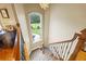 Carpeted staircase with decorative railings and a large window with outdoor view at 4239 Lower Jersey Rd, Covington, GA 30014