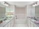 Luxurious bathroom featuring a soaking tub, double vanities, granite countertops, and elegant tile flooring at 4571 Academy St, Acworth, GA 30101