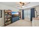 Bright bedroom featuring a ceiling fan, window with curtains, and shelving with books at 4571 Academy St, Acworth, GA 30101