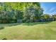 Expansive backyard features lush green grass, mature trees, and a charming privacy fence at 2321 Sunnyview Ln, Dacula, GA 30019
