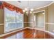 Elegant dining room with wood flooring, classic chandelier, and large window at 2321 Sunnyview Ln, Dacula, GA 30019