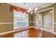 Elegant dining room with wood flooring, classic chandelier, and large window at 2321 Sunnyview Ln, Dacula, GA 30019