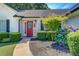 Close up of front entrance, with a red door and landscaped yard with flowering bushes at 2321 Sunnyview Ln, Dacula, GA 30019
