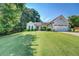 Well-maintained home with a manicured lawn, lush greenery, and a charming red front door at 2321 Sunnyview Ln, Dacula, GA 30019
