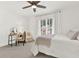 Well-lit bedroom featuring a fan, a large window, neutral carpet, and a small writing desk at 12 Ivy Ne Rdg, Atlanta, GA 30342