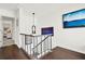 A hallway with dark hardwood floors, a gray railing, and a view of wall art at 12 Ivy Ne Rdg, Atlanta, GA 30342