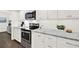 Well-lit kitchen featuring stainless steel appliances and white cabinets with stone countertops at 12 Ivy Ne Rdg, Atlanta, GA 30342