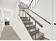 Gray carpeted staircase with a gray railing and art on the walls in a bright hallway at 12 Ivy Ne Rdg, Atlanta, GA 30342