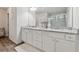 Bathroom vanity with granite countertops, double sinks, white cabinets, and a view of the glass-enclosed shower at 404 Arden, Ellenwood, GA 30294