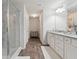 Bright bathroom with granite counters, double vanity, walk-in shower with marble-like tiles, and wood-look floors at 404 Arden, Ellenwood, GA 30294