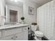 Bright bathroom featuring a granite countertop, white cabinets, decorative accents, and a shower with a patterned curtain at 404 Arden, Ellenwood, GA 30294
