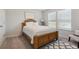 Inviting bedroom with wood frame bed, neutral color palette, large windows, a comfy rug and accent chair at 404 Arden, Ellenwood, GA 30294
