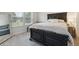 Comfortable bedroom with a stylish black bed frame, cozy bedding, and a window offering natural light and neighborhood views at 404 Arden, Ellenwood, GA 30294