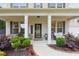 Welcoming covered front porch featuring brickwork, columns, seating, and manicured landscaping at 404 Arden, Ellenwood, GA 30294