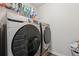 Laundry room featuring modern Samsung washer and dryer, with shelving for organizing cleaning supplies at 404 Arden, Ellenwood, GA 30294
