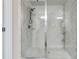 Close-up of glass shower with marble-look tile surround, and showerhead with integrated shower controls at 404 Arden, Ellenwood, GA 30294