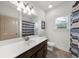 Bright bathroom featuring vanity, a large mirror, and a shower with custom tiling at 4425 Martel Dr, Cumming, GA 30040
