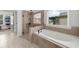 Bathroom featuring tile flooring, enclosed shower with tiled walls, large soaking tub, and a window at 4425 Martel Dr, Cumming, GA 30040