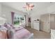 Charming bedroom with a decorative ceiling fan, dresser and a sunlit window at 4425 Martel Dr, Cumming, GA 30040
