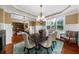 Open dining room with chandelier lighting and wainscoting, adjacent to other living areas at 4425 Martel Dr, Cumming, GA 30040