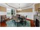Formal dining room with large windows, chandelier, and seating for six; great for entertaining at 4425 Martel Dr, Cumming, GA 30040