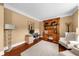 Bright home office space featuring a built-in wooden bookcase, desk, and a comfortable armchair at 4425 Martel Dr, Cumming, GA 30040