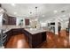 Open kitchen with granite countertops, stainless appliances, and hardwood floors, flowing into an open living space at 4425 Martel Dr, Cumming, GA 30040