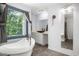 The stylish bathroom features a freestanding tub, a bowl sink, a frameless mirror, and a large window at 2085 Castle Royale Dr, Lawrenceville, GA 30043