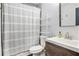 Bright bathroom featuring a shower with a striped curtain, modern vanity, and storage shelf at 2085 Castle Royale Dr, Lawrenceville, GA 30043