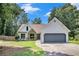 Charming home with a well-maintained lawn, stone accents, a gray two-car garage and lush landscaping at 2085 Castle Royale Dr, Lawrenceville, GA 30043