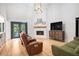 Open concept living room with a fireplace, hardwood floors and access to the outdoor pool at 2085 Castle Royale Dr, Lawrenceville, GA 30043