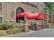 Elegant building entrance features a red awning and manicured landscaping for an inviting feel at 2865 Lenox Ne Rd # 103, Atlanta, GA 30324