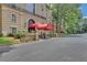 Elegant building entrance features a red awning and manicured landscaping for an inviting feel at 2865 Lenox Ne Rd # 103, Atlanta, GA 30324