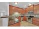 Kitchen boasting wood cabinets, granite counters, tile backsplash, and stainless steel appliances at 2865 Lenox Ne Rd # 103, Atlanta, GA 30324