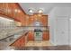 Kitchen with wood cabinets, stainless steel appliances, granite countertops, and tile flooring at 2865 Lenox Ne Rd # 103, Atlanta, GA 30324