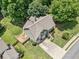 Aerial view of home with green siding, neutral colored roof, driveway, and well-maintained landscaping at 3372 English Oaks Nw Dr, Kennesaw, GA 30144