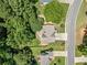 Aerial view of home with green roof surrounded by mature trees, driveway, and street view at 3372 English Oaks Nw Dr, Kennesaw, GA 30144
